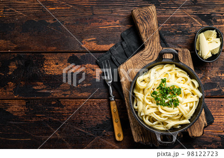 German Spaetzle egg Noodles with Butter and Parsley in a skillet. Wooden background. Top view. Copy space German Spaetzle egg Noodles with Butter and Parsley in a skillet. Wooden background. Top view. Copy space 98122723