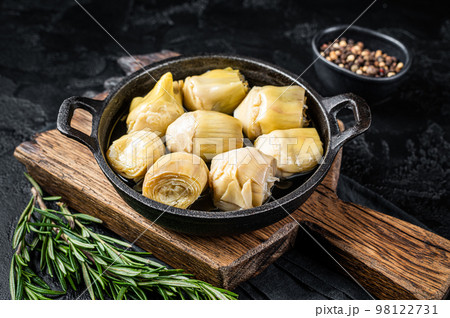 Artichoke hearts pickled in olive oil with herbs and spices Black background. Top view 98122731