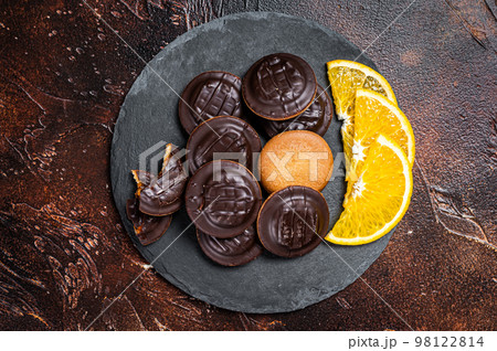 Stack of Chocolate Covered Round Jaffa Cookies with Orange Flavored Marmalade. Dark background. Top view Stack of Chocolate Covered Round Jaffa Cookies with Orange Flavored Marmalade. Dark background. Top view 98122814
