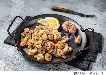Grilled Shrimps prawns with garlic, olive oil and lemon in a tray. Gray background. top view Grilled Shrimps prawns with garlic, olive oil and lemon in a tray. Gray background. top view 98122891