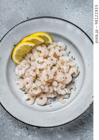 Boiled shrimps seafood with lemon, herbs and spice, prawns peeled. Gray background. top view Boiled shrimps seafood with lemon, herbs and spice, prawns peeled. Gray background. top view 98122933