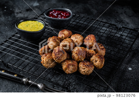 Swedish meatballs with lingonberries and gravy sauce. Black background. Top view 98123076