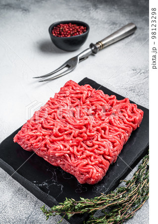 Raw mince Minced beef, ground meat with thyme and pepper. White background. Top view 98123298
