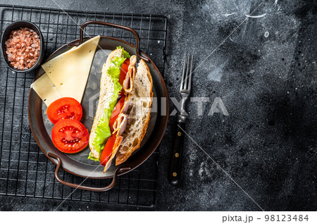 Deli meat sandwich with turkey ham, cheese, tomato and Lettuce. Black background. Top view. Copy space Deli meat sandwich with turkey ham, cheese, tomato and Lettuce. Black background. Top view. Copy space 98123484