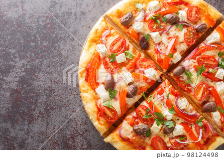 Homemade Greek pizza featuring feta, roasted red peppers, olive, tomato, onions closeup on wooden board. Horizontal top view Homemade Greek pizza featuring feta, roasted red peppers, olive, tomato, onions closeup on wooden board. Horizontal top view 98124498