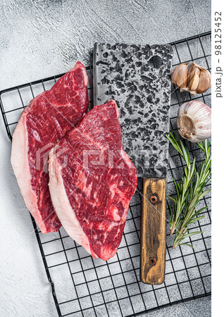 Raw top sirloin beef meat steak on a butcher cleaver, cap rump steak. White background. Top view 98125452