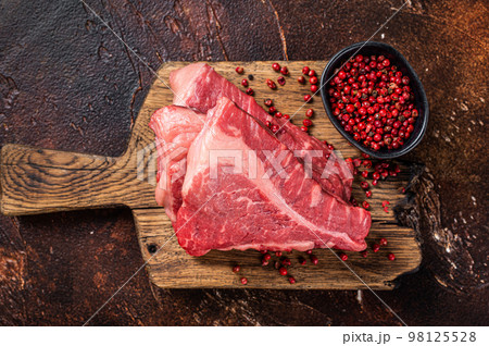 Raw sirloin beef cut, Silverside steak on a wooden board. Dark background. Top view 98125528