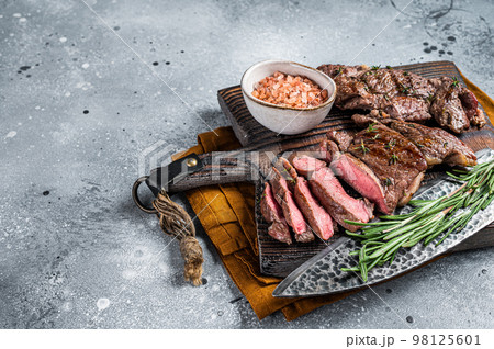 Roasted Mutton leg steaks, sliced lamb meat. Gray background. Top view. Copy space 98125601