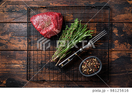 Rump steak with spices, raw beef meat. Wooden background. Top view Rump steak with spices, raw beef meat. Wooden background. Top view 98125616