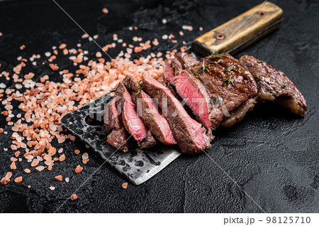 Sliced grilled Lamb fillet steak, mutton meat from leg. Black background. Top view Sliced grilled Lamb fillet steak, mutton meat from leg. Black background. Top view 98125710