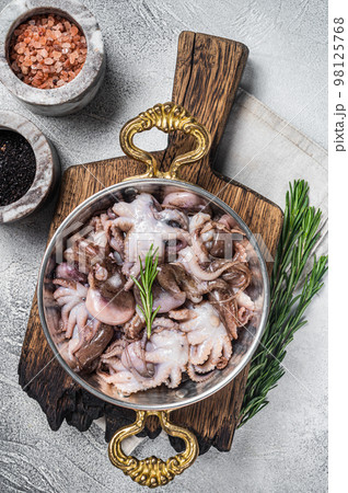 Ready for cooking raw mini baby octopus in a skillet. White background. Top view Ready for cooking raw mini baby octopus in a skillet. White background. Top view 98125768