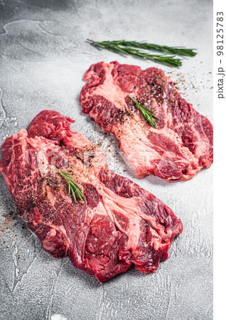 Marbled raw meat Steaks cooking with seasonings and olive oil, fresh beef rib eye steaks. White background. Top view Marbled raw meat Steaks cooking with seasonings and olive oil, fresh beef rib eye steaks. White background. Top view 98125783