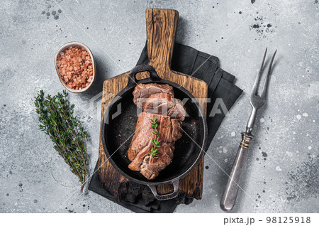 Roast Beef tenderloin, roasted meat in skillet with thyme. Gray background. Top view 98125918