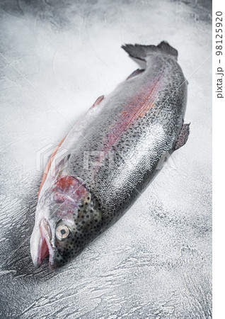Raw trout silver fish on a kitchen table. Gray background. Top view Raw trout silver fish on a kitchen table. Gray background. Top view 98125920