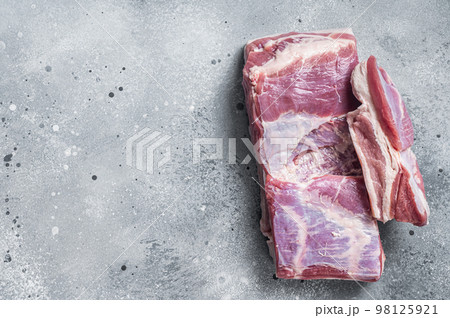 Raw pork belly with skin on a butcher table. Gray background. Top view. Copy space 98125921
