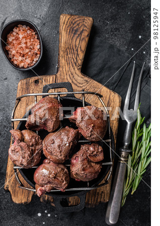 Grilled Beef veal kidney, offal meat on grill. Black background. Top view 98125947