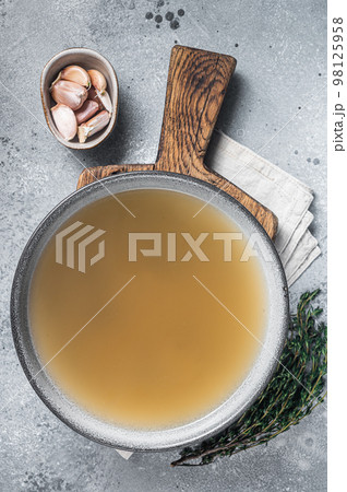 Bone meat chicken broth in a plate. Gray background. Top view 98125958