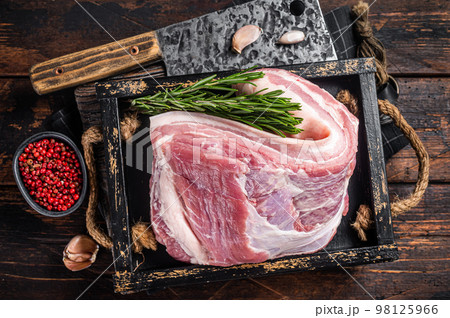 Organic uncooked Pork belly, raw bacon meat in a wooden plate with thyme. Wooden background. Top view Organic uncooked Pork belly, raw bacon meat in a wooden plate with thyme. Wooden background. Top view 98125966