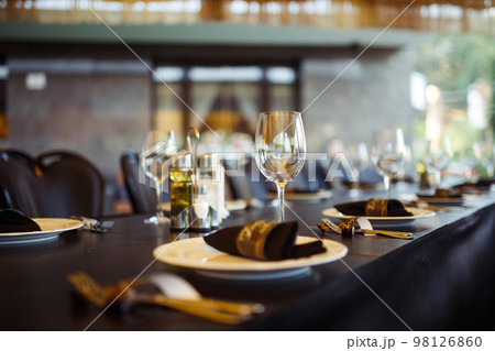 Sparkling glassware stands on long table prepared for wedding dinner. Sparkling glassware stands on long table prepared for wedding dinner. 98126860