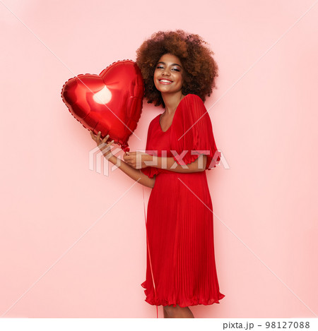 A beautiful young African-American woman with heart shape air balloon 98127088