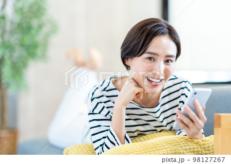 ソファーでスマホを操作する女性 98127267