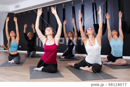 Women practicing yoga at gym 98128077