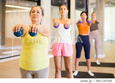Mature female performing set of exercises with pilates ball Mature female performing set of exercises with pilates ball 98128566