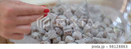 Woman hand takes sweet Turkish delight closeup 98128863