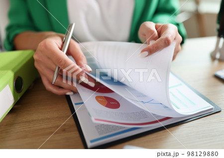 Female manager working with financial and marketing documents at her desk. 98129880