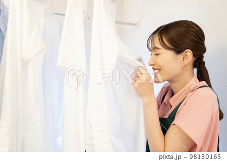 風呂場に干したシャツの匂いを嗅いで微笑む女性 風呂場に干したシャツの匂いを嗅いで微笑む女性 98130165
