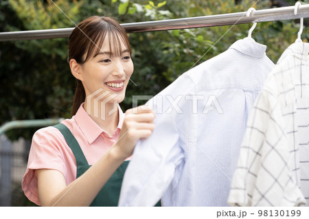 洗濯したシャツを干す女性 洗濯したシャツを干す女性 98130199
