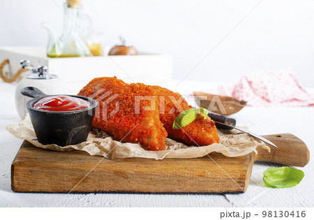Fried chicken breast fillet in batter with sauce 98130416