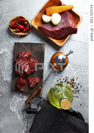 Raw liver on slate board on wooden background top view Raw liver on slate board on wooden background top view 98130534