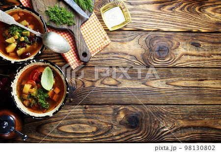 Chili soup in bowl with corn and been on dark background. Mexican cuisine. Top view 98130802