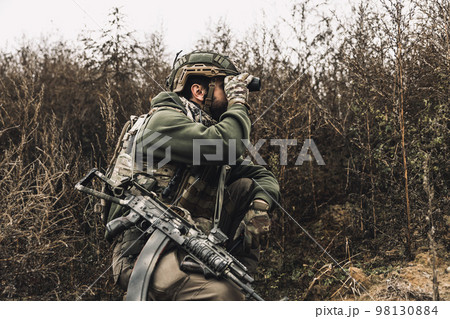 Soldier with binocular investigating the place Soldier with binocular investigating the place 98130884