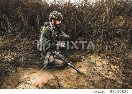 Soldier with binocular investigating the place 98130885