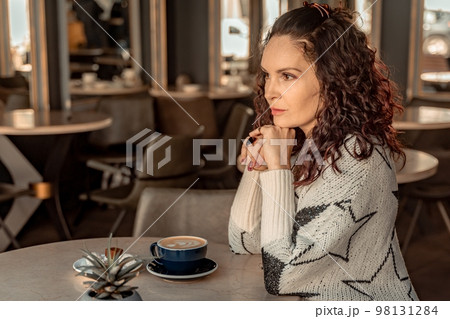 Woman cafe coffee breakfast. Portrait of an adult beautiful woman in an elegant suit in a cafe Woman cafe coffee breakfast. Portrait of an adult beautiful woman in an elegant suit in a cafe 98131284