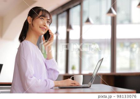 電話で思い出しながら話す若い女性_1 98133076