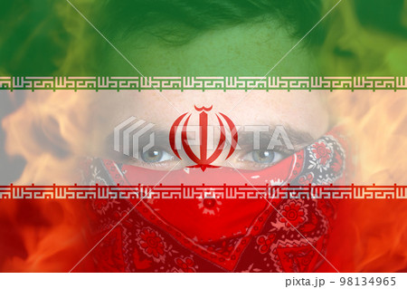 Defocus protest in Iran. Face young man in bandana. Conflict war over border. Fire, flame. Closeup man face. Country flag. Out of focus Defocus protest in Iran. Face young man in bandana. Conflict war over border. Fire, flame. Closeup man face. Country flag. Out of focus 98134965