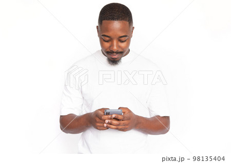 Concentrated young man typing message on smartphone Concentrated young man typing message on smartphone 98135404