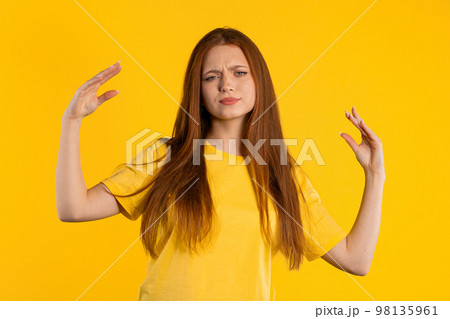 Irritated ginger woman showing bla-bla-bla gesture with hands, rolling eyes on yellow background Irritated ginger woman showing bla-bla-bla gesture with hands, rolling eyes on yellow background 98135961