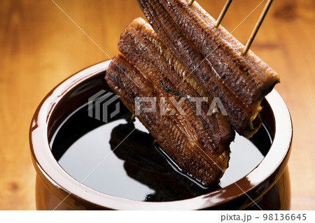 鰻の蒲焼きを秘伝のタレに漬ける 98136645