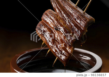 鰻の蒲焼きを秘伝のタレに漬ける 98136657