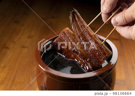 鰻の蒲焼きを秘伝のタレに漬ける 98136664