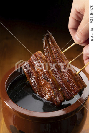 鰻の蒲焼きを秘伝のタレに漬ける 98136670