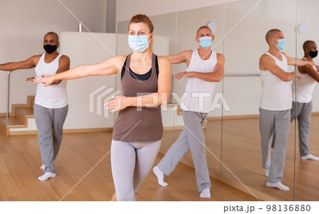 People in protective masks learning swing steps at class People in protective masks learning swing steps at class 98136880