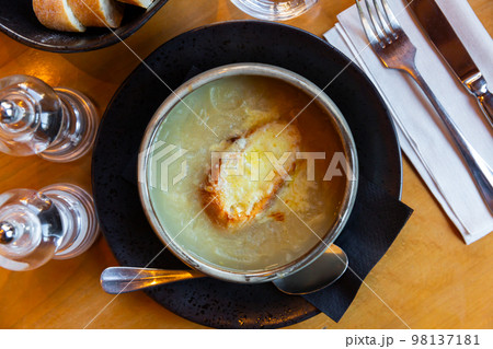 Gratin onion soup served with piece of crouton and cheese 98137181