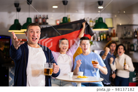 Enthusiastic German fans scream with joy in beer bar. Germany victory 98137182