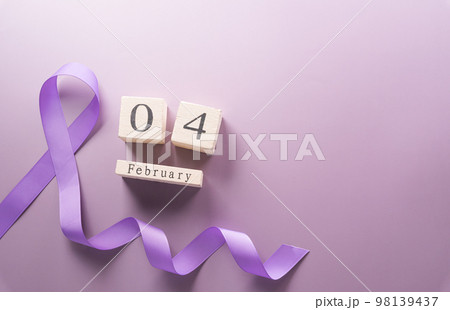 Purple ribbon and wooden calendar on pastel paper background for supporting World Cancer Day campaign on February 4. 98139437