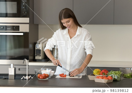Slim beautiful woman preparing vegetable salad in the kitchen Slim beautiful woman preparing vegetable salad in the kitchen 98139812
